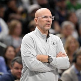 Dallas Mavericks head coach Jason Kidd covers his arms.